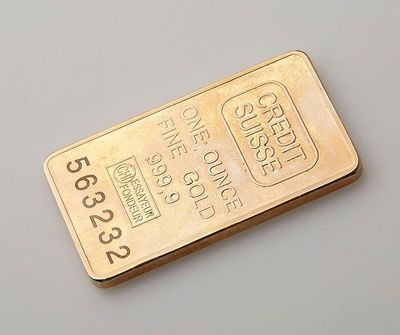 gros plan d'un lingot d'or sur une surface blanche