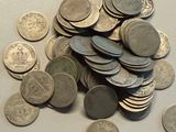 a pile of coins sitting on a table next to a cell phone