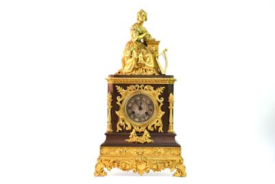 une horloge en or surmontée d'une statue