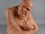 an image of a clay sculpture of a man with a hand on his chest