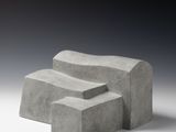 trois blocs de béton empilés les uns sur les autres sur une surface blanche