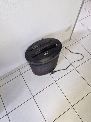une poubelle posée par terre à côté d'une autre poubelle