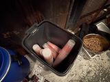 a bucket full of pills sitting on the floor next to a trash can