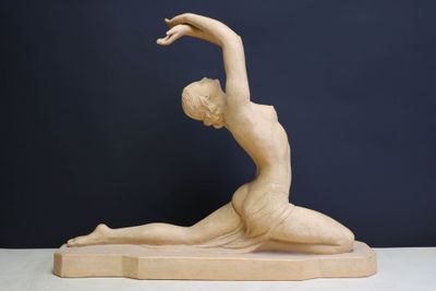 statue d'une femme dans une posture de yoga, posée sur un socle en bois