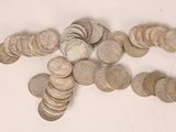 a pile of silver coins on a white surface