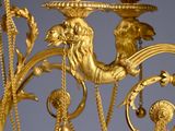 a gold colored chandelier with a bird on it