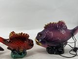 three ceramic fish figurines are sitting next to each other on a white surface