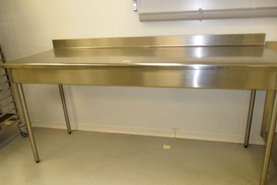 a stainless steel table with a sink in a kitchen