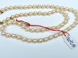 a white pearl necklace with a tag on it