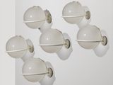 Six ampoules blanches sont accrochées à un mur blanc dans une pièce