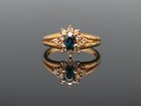 a close up of a gold ring with blue and white diamonds
