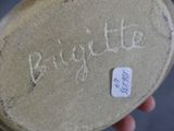 a person holding a piece of pottery with writing on it