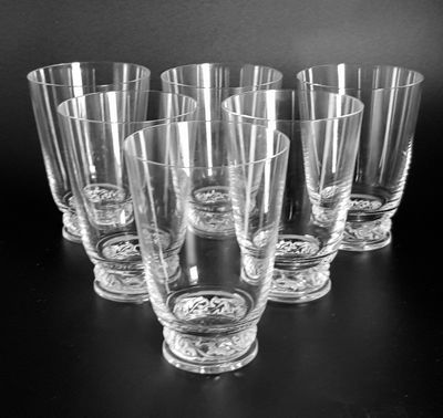 six glasses are lined up on a table with a black background