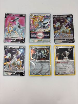 quatre cartes Pokémon différentes posées sur une surface blanche