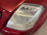 a close up of a car ' s headlight on a red car