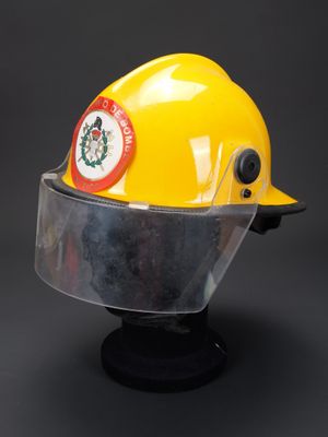 casque de chantier jaune muni d'un viseur transparent et d'un badge sur le dessus