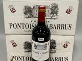 une bouteille de vin posée à côté de deux cartons de vin