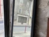 un miroir posé sur le rebord d'une fenêtre, devant celle-ci