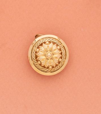 un gros plan sur une boucle dorée posée sur une surface rose