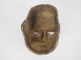 an old bronze mask on a white background with a hole in the middle