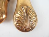 a pair of gold shoes that are on a white table