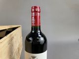 a bottle of wine sitting on a table next to a wooden box
