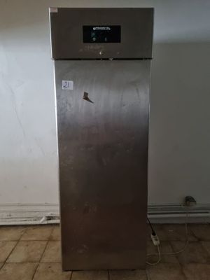 une photo d'un réfrigérateur dans une cuisine, avec une horloge sur la porte