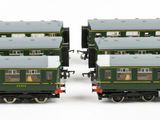 two green train cars sitting side by side on a white surface