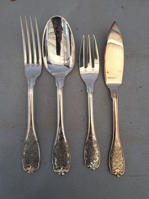 quatre fourchettes, un couteau et une cuillère posés sur une table