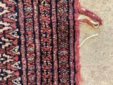 a close up of a red and black rug on the floor