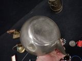 a person holding a silver tea pot in their hand