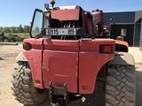 a red tractor that is parked in the dirt
