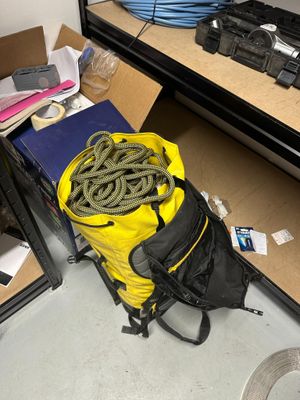 un sac de corde et un sac de bagages par terre
