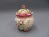 un petit pot muni d'un couvercle orné de fleurs