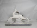 white ceramic sculpture of a horse on a rock with a bird on its back