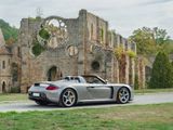 a silver sports car parked in front of an old building