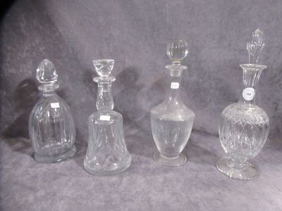 four clear glass bottles sitting next to each other on a gray surface