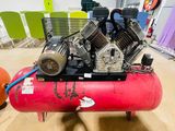 a red air compressor sitting on top of a red tank