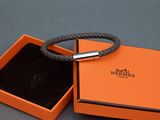 une boîte orange contenant un bracelet, posée sur une surface grise