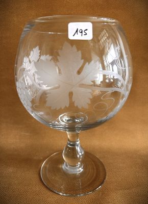 a glass with a leaf design on it on a table