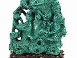 sculpture of a group of people on a rock with a tree in the background
