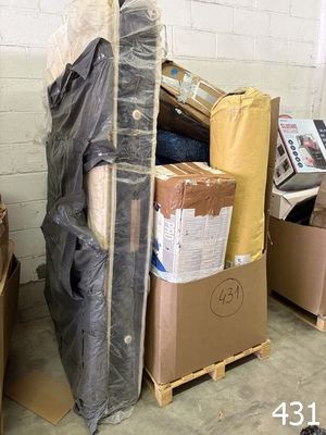 a pile of boxes and a mattress on a pallet in a warehouse