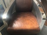 brown leather office chair in corner of room with desk and computer monitor