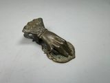 an antique brass hand holding a flower broocher