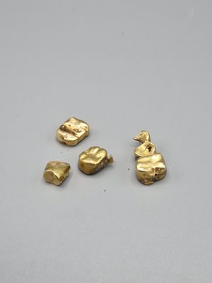 quatre pièces de métal doré sur un fond blanc