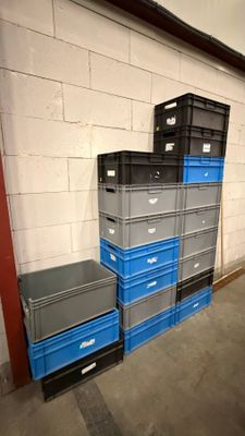 une pile de caisses bleues et grises dans un entrepôt