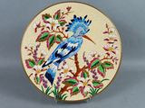 une assiette décorative sur laquelle est peint un oiseau