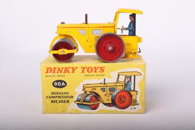 yellow toy tractor sitting on top of a yellow box on a white surface