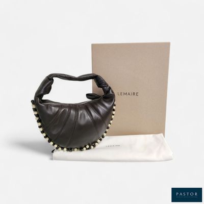 the black leather purse is next to a box and a white cloth