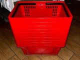 a red plastic crate sitting on the floor next to a door